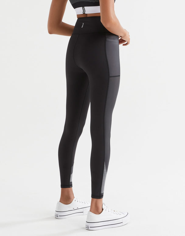 Woman wearing black sporty leggings, sports bra and white sneakers.