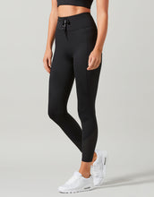 Women wearing black activewear leggings with a grey background