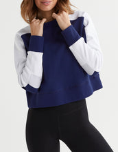 Person wearing a blue and white color-blocked sweatshirt on a white background