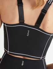 Black waist trainer with straps on a person, featuring the brand 'lilybody'.