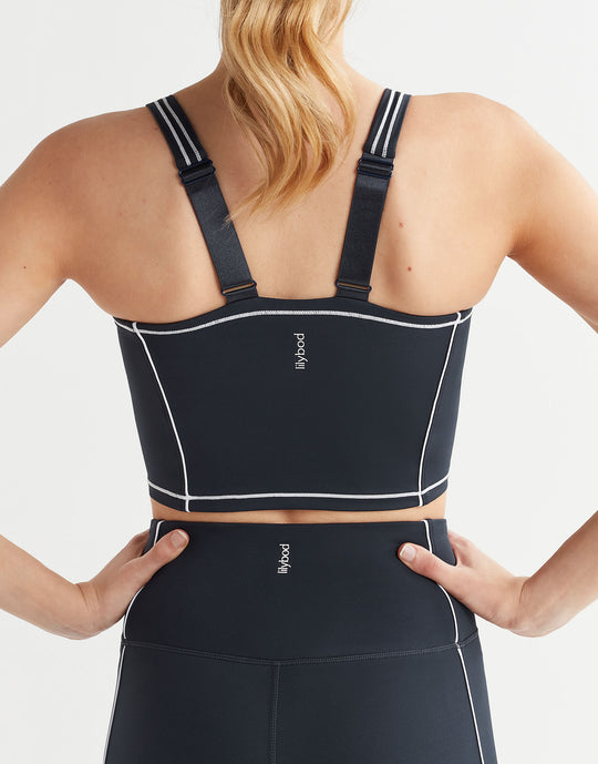 Black sports bra with straps on a person against a white background
