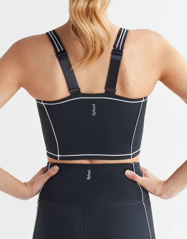 Black sports bra with straps on a person against a white background