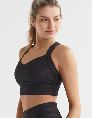 Woman wearing a black sports bra and leggings on a white background