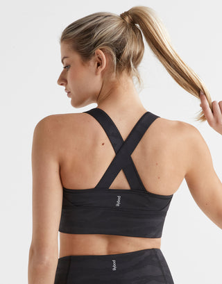 Woman wearing a black sports bra by Holistic Femme