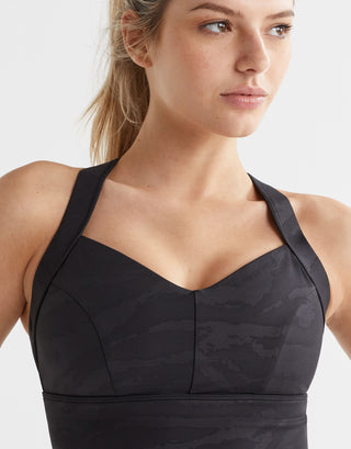 Woman wearing a black sports bra on a white background