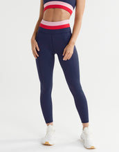 Person wearing navy leggings with a white background