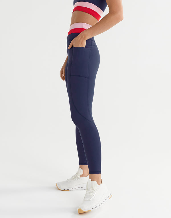 Person wearing navy leggings with a white background