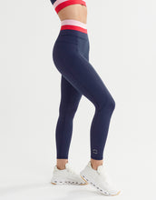 A woman wearing blue, red and pink leggings and white runners