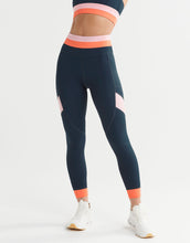 Navy leggings with pink and orange accents worn by a person on a white background