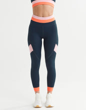 Navy leggings with pink and orange accents worn by a person on a white background