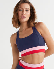 Woman wearing a sports bra with a colorful design on a white background
