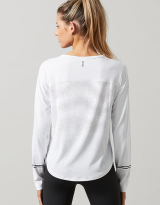 Woman wearing a white long-sleeve athletic shirt on a gray background