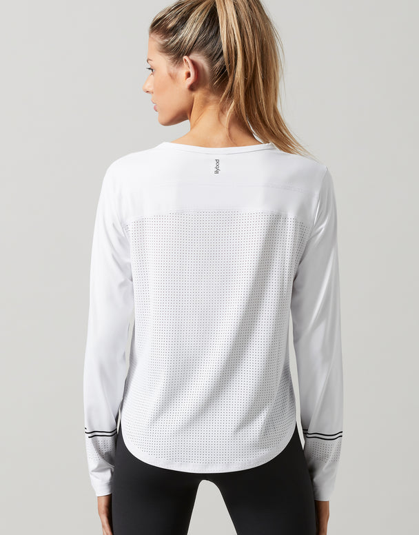 Woman wearing a white long-sleeve athletic shirt on a gray background