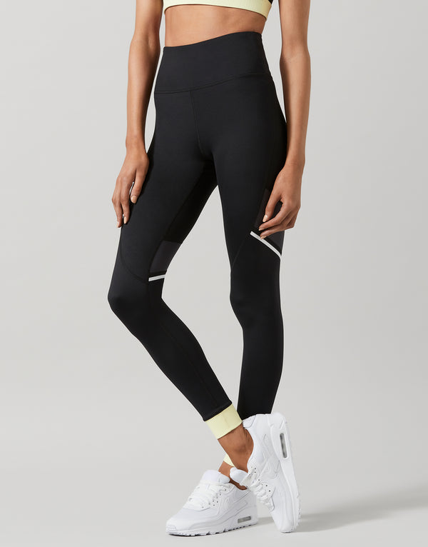 Person wearing black leggings with a plain background