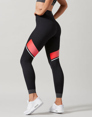 Black leggings with red accents worn by a person on a light gray background