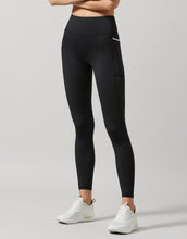 A pair of high-waisted, full-length leggings in smoke black color, featuring breathable mesh panels and two pockets at the hip.