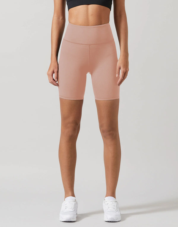 A model wearing beige workout shorts and a black top.