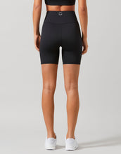A model in a pair of high-waisted black bike shorts with a 6-inch inseam, designed for women. The shorts are solid black, and the image shows the shorts in a full-body view with the waist at the top.
