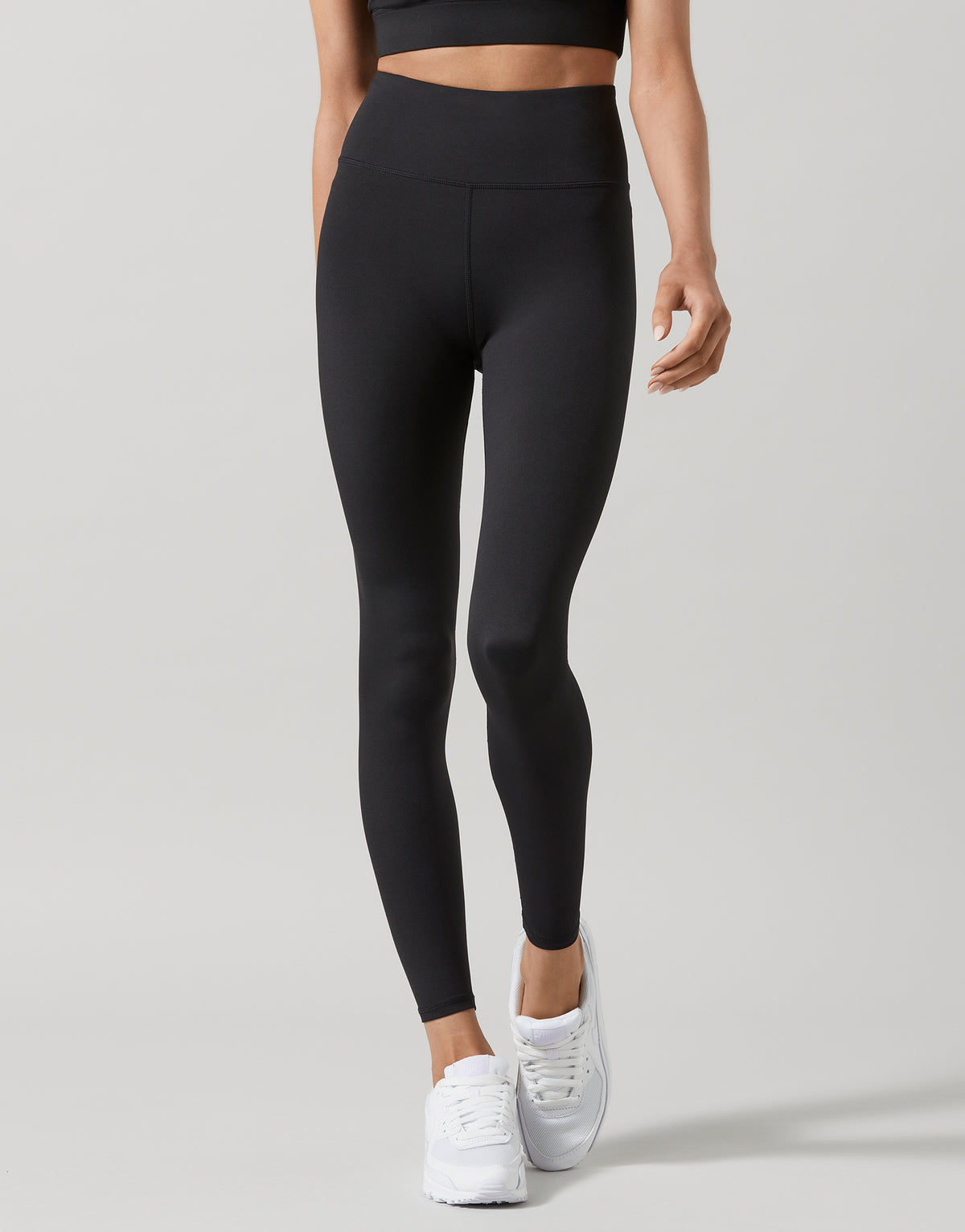 A model wearing Lilybod black high-waisted full-length leggings.