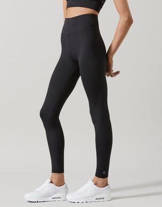 A model wearing black high-waisted full-length leggings and a top.
