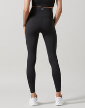 Person wearing black leggings on a light gray background