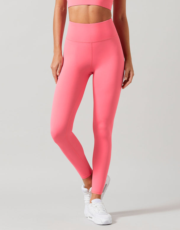 Person wearing bright pink leggings on a plain background