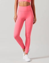 Person wearing bright pink leggings and a matching top on a light gray background