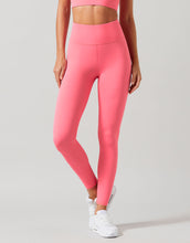 Person wearing bright pink leggings and a matching top on a light gray background