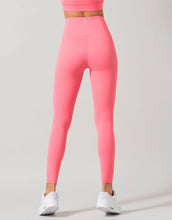 Person wearing bright pink leggings on a gray background