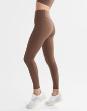 Brown leggings worn by a person on a white background