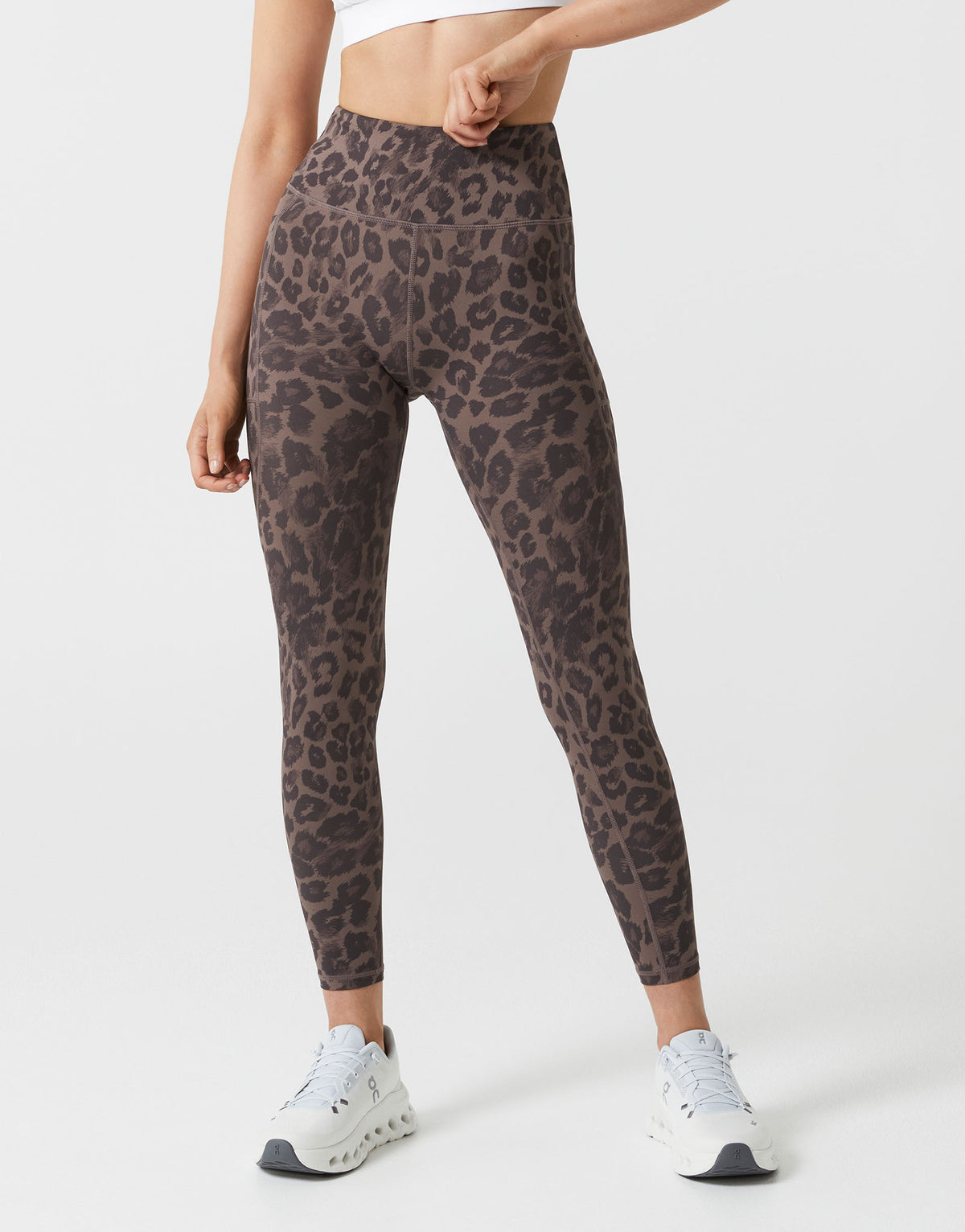 Person wearing leopard print leggings on a white background