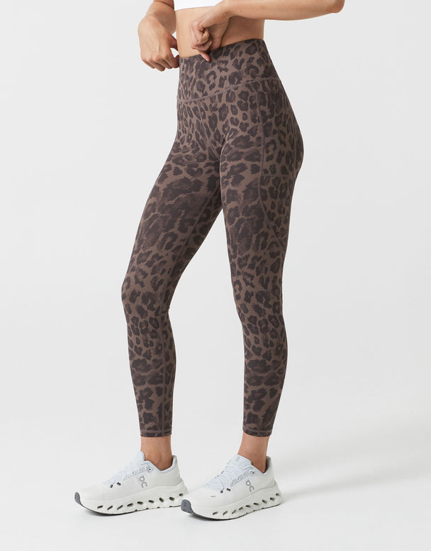 Person wearing leopard print leggings on a white background