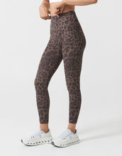 Person wearing leopard print leggings on a white background