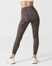 Leopard print leggings worn by a person on a white background