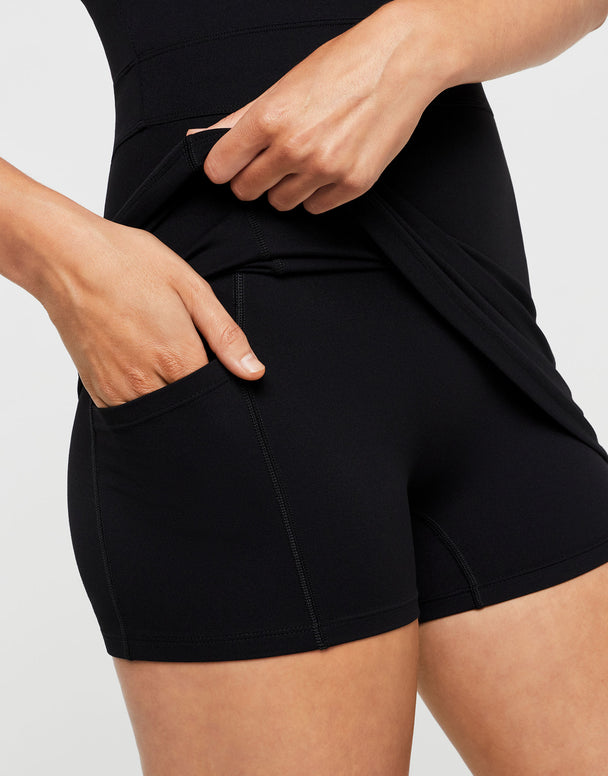 Person wearing black shorts with a plain background