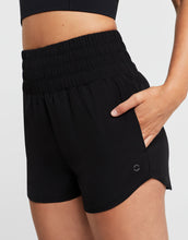 Black athletic shorts worn by a person on a light gray background