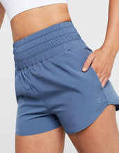Blue athletic shorts worn by a person on a white background