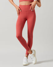 Person wearing red leggings and white sneakers on a light gray background