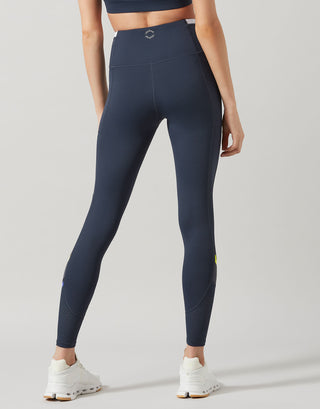 Person wearing navy leggings on a light gray background