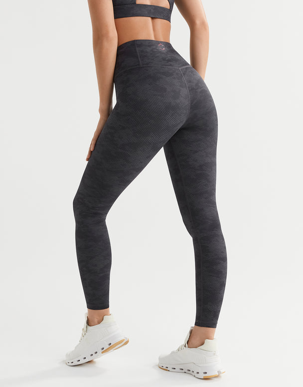 Person wearing dark gray leggings on a white background
