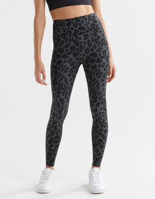 A pair of high-waisted grey leggings with a leopard print pattern, full length, and a visible brand logo at the back waist.