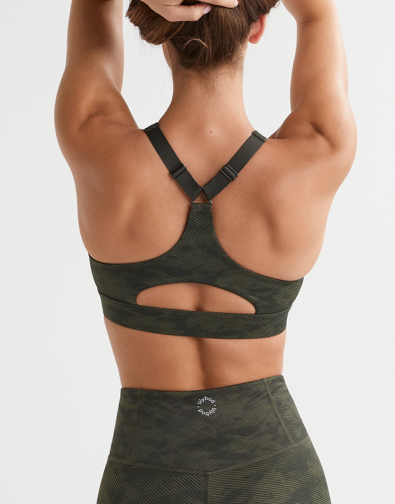 A woman wearing a green camo sports bra.
