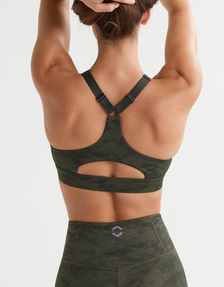 A woman wearing a green camo sports bra.