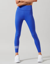Womens blue leggings with white stripes on a gray background
