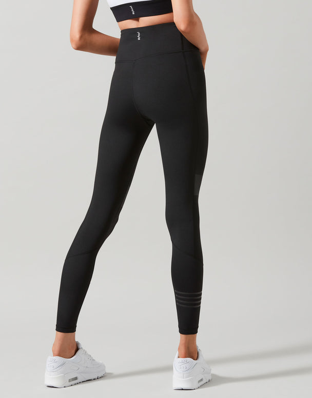 Person wearing black leggings on a light gray background