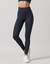 Person wearing navy leggings on a light gray background