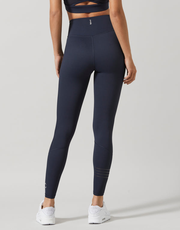 Person wearing navy Lilybod leggings on a light gray background