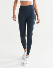 Person wearing navy leggings with white stripes on a white background