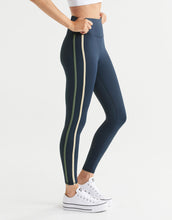 Navy leggings with white stripes worn by a woman on a white background