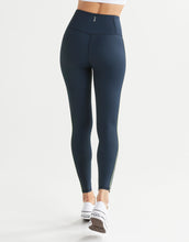Navy blue leggings worn by a person on a white background